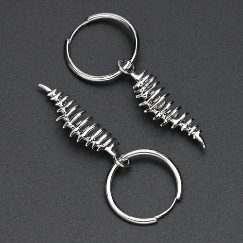Two silver keychains with spiral designs on a dark gray background