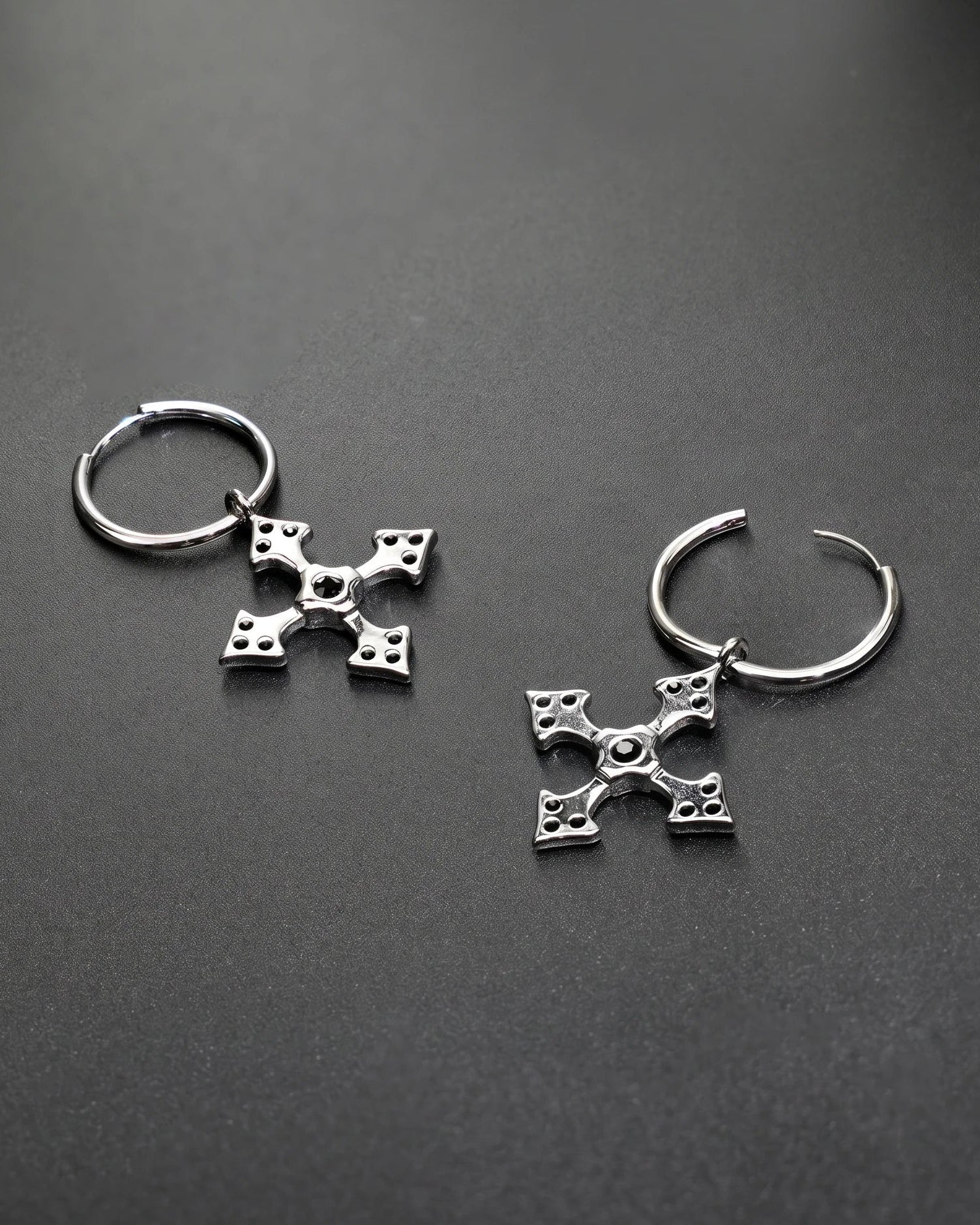 Silver hoop earrings with decorative elements on a dark gray background