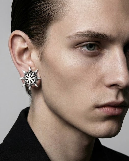 Close-up of a person wearing a star-shaped earring against a neutral background